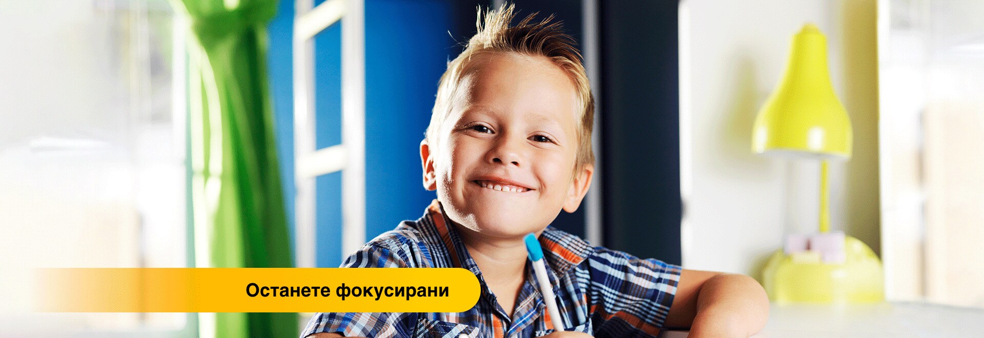 Усмихващо се момче, концентриращо се над домашна работа.